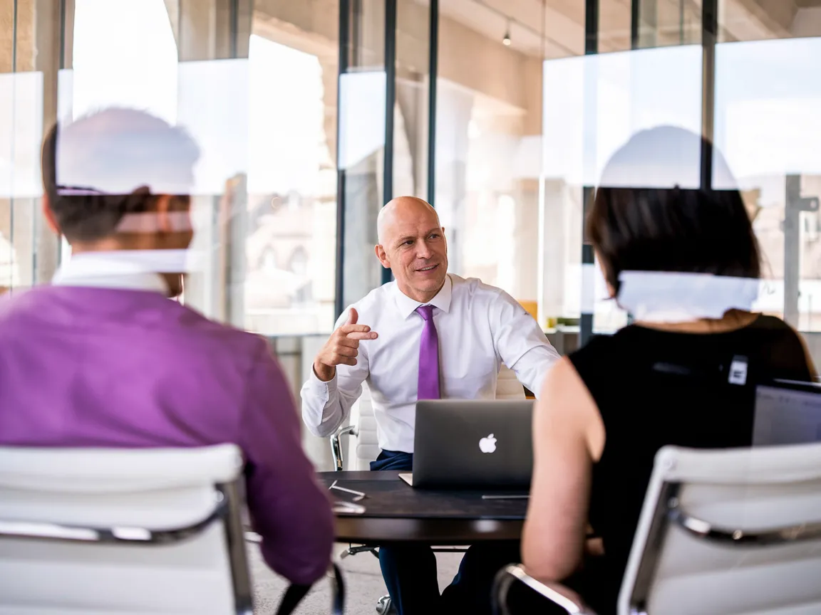 KI-generiertes Business-Bild: Rrevival CEO im Meeting mit violetter Krawatte — Schweizer Stadtsilhouette